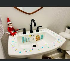 an elf is sitting in the bathroom sink