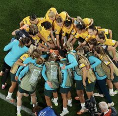 a group of women in yellow and blue uniforms huddle together on the soccer field