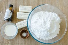 ingredients to make homemade vanilla ice cream sitting on a wooden counter top next to a glass bowl