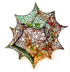 an intricate spider web sculpture on a white background