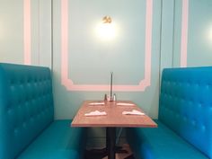 two blue booth booths with white napkins on them in a dining area at a restaurant