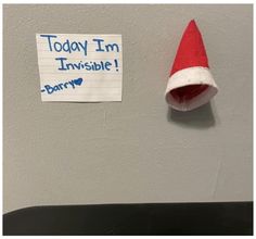 a santa hat hanging on the wall next to a sign that says today i'm invisible