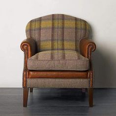 a brown chair sitting on top of a hard wood floor next to a white wall