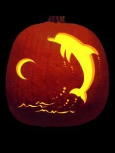 a carved pumpkin with an image of a dolphin in the water on it's face