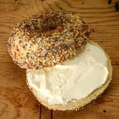 two bagels with white frosting and sprinkles sit on a wooden table