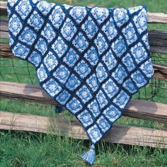 a blue and white blanket sitting on top of a wooden fence