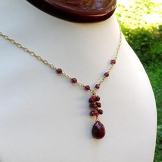 A gorgeous genuine ruby gemstone is accented with real ruby and garnet clusters to create an elegant and unique handmade necklace. The deep reds of the garnets are mixed with the bright rubies and both complement the finely faceted natural ruby stone pendant. A unique and artisan birthday gift for a woman born in July since ruby is her birthstone.Necklace Details:- Necklace is 18 inches long (45.72 cm) plus an additional 1 inch (2.54 cm) extender- Pendant is 1.25 inches long with the gemstone cl Faceted Ruby Jewelry For Jewelry Making, Red Garnet Drop Jewelry, Handmade Teardrop Ruby Jewelry, Garnet Briolette For Jewelry Making, Handmade Ruby Teardrop Jewelry, Ruby Briolette Gemstone Jewelry, Teardrop Garnet For Jewelry Making, Garnet Briolette Beads For Jewelry Making, Teardrop Garnet Gemstone Jewelry