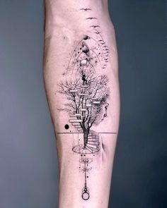 a man's leg with a tree and compass tattoo on it, in black and white