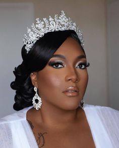 a woman wearing a tiara and makeup looks at the camera while posing for a photo