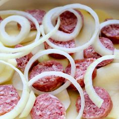 sliced sausage and onions are being prepared in an oven