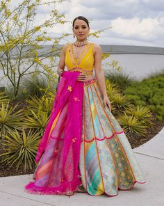 A multi-colored brocade mosaic scalloped lehenga paired with a yellow silk blouse and a pink tulle dupattaFrom Liz Paul’s Signature collection DELIVERY TIMEPlease allow 8-12 weeks for your outfit to arrive. FABRIC DETAILSRaw silk. Professional cleaning only. Liz Paul Lehenga, Fusion Style Festive Silk Lehenga, Fusion Multicolor Designer Wear Sets, Festive Fusion Multicolor Dress, Fusion Style Multicolor Designer Sets, Fusion Style Multicolor Sets For Navratri, Multicolor Fusion Sets For Navratri, Multicolor Navratri Sets, Fusion Style Multicolor Choli For Navratri