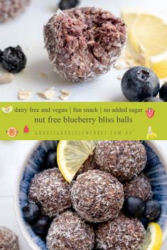 blueberry bliss balls are in a bowl with lemons and blackberries on the side