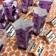 purple halloween treat bags with bats and ghostes on them, sitting on a table