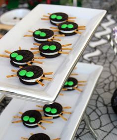 some cookies with green eyes on them are sitting on a table next to other desserts