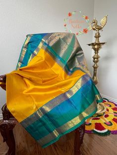 Traditional mango yellow and teal double border (rettai pettu) kanchipuram pure silk saree. With peacock and Rudraksh motifs woven alternating all over the body.The border has graceful peacock motifs which runs along the pallu with paisley motif intricately woven to give a complete rich look. Comes with falls, pico and tassels. Blouse details: Front hook with back strings chest size: 38 inches with 3 inch margin waist size: 32 inches with 3 inch margin sleeve length: 11 inch Front length:15 inch Yellow And Teal Clothing Accessories, Yellow Handloom Katan Silk Traditional Wear, Yellow Katan Silk Traditional Wear Handloom, Yellow Tussar Silk Saree With Pallu, Yellow Tussar Silk Saree With Pallu Detail, Yellow Tussar Silk Saree For Festivals, Yellow Paithani Silk Traditional Wear With Self Design, Navratri Yellow Paithani Silk Dupatta, Yellow Paithani Silk Dupatta For Navratri