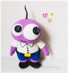 a crocheted purple and white stuffed animal with big eyes on it's head