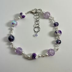 a floral grape colored bracelet that feels like a European spring day. If your a fan of purple this is a great touch to your jewelry. Made with  quality beads and strong links. Adjustable Purple Flower Beaded Bracelets, Purple Flower-shaped Beaded Bracelets, Purple Flower Shaped Beaded Bracelets, Elegant Purple Beaded Charm Bracelet, Purple Beaded Flower Bracelets, Adjustable Purple Bracelets For Spring, Elegant Purple Charm Bracelet With Round Beads, Purple Flower Jewelry For Spring, Elegant Hypoallergenic Purple Beaded Bracelets