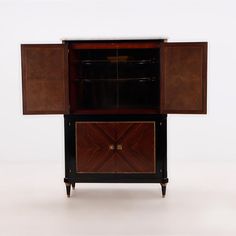 the cabinet is made from wood and has two doors on one side, and an open drawer on the other