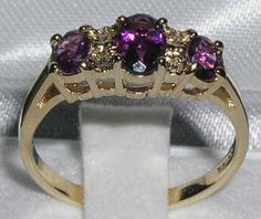 *This beautiful ring is made from 375 9K (9ct 9Kt) Yellow Gold with Genuine Natural 1.12 carats Semi-precious Amethysts & Genuine Natural 0.04 carats Precious Diamonds.*Total metal weight : 1.9gA beautiful traditional style Amethyst set with a center 6x4mm (0.24" x 0.20" inches) and two 5x4mm (0.20" x 0.16" inches) vibrant Amethysts and four Diamonds in an adorable 9K Yellow Gold setting.*Total Height 3mm, Width 16mm,  Length 6mm   Completely made from Solid English 9K Yellow Gold Hallmarked Anniversary Yellow Gold Three-stone Amethyst Ring, Classic Three Stone Amethyst Ring For Anniversary, Gold Three-stone Amethyst Ring For Anniversary, Engagement Ring Trilogy, Amethyst Set, Yellow Gold Setting, Pink Tourmaline, Diamond Engagement Ring, Ring Verlobung