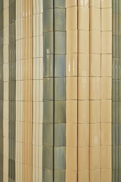 the wall is made up of different colored ceramic tiles and has vertical stripes on each side