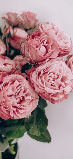 a vase filled with pink flowers on top of a table