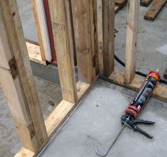 a screwdriver laying on the ground in front of some wooden posts and studs