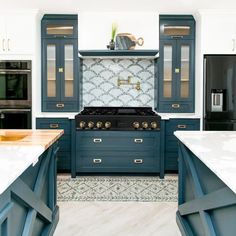 a kitchen with blue cabinets and white counter tops, an oven and stove top in the center