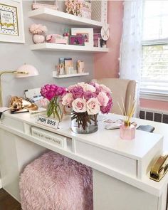 a white desk topped with lots of pink flowers