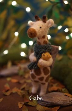 a small stuffed giraffe holding a smaller stuffed animal