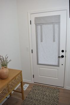 a white door with a towel hanging on it's side rail next to a wooden table