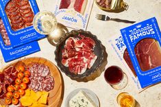 various meats and cheeses are displayed on a table