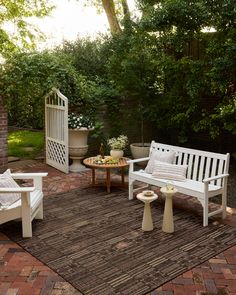 an outdoor patio with white furniture and potted plants