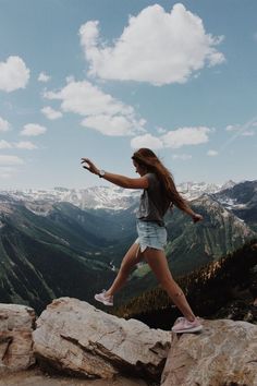 a woman standing on top of a rocky cliff