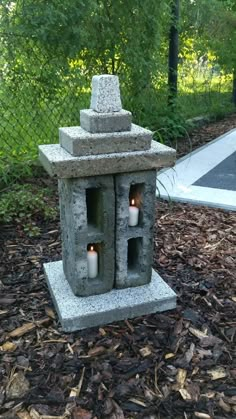 two candles are lit in a cement lantern