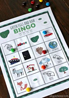 a printable green egg and rain bingo game on a wooden table with candies