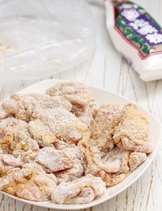 a white bowl filled with powdered sugar on top of a table