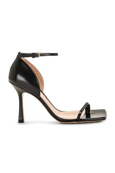 Find BOTTEGA VENETA Stretch Sandal on Editorialist. Bottega Veneta Stretch Sandal in Black Lambskin leather upper with rubber-injected leather sole. Made in Italy. Ankle strap with buckle closure. Toe loop. Lambskin leather lining. Square toe with block heel. Approx 95mm/ 3.75 inch heel. BOTT-WZ409. 729742-VBSF0-1000. About the designer: Bottega Veneta – inspiring individuality with innovative craftmanship since 1966. Creativity lies at the heart of all that we do. Born in Vicenza the house is rooted in Italian culture yet maintains a truly global outlook. An inclusive brand with exclusive products Bottega Veneta is as much of a feeling as it is an aesthetic. Leather Heels With Sculpted Heel For Gala, Designer Ankle Strap Heels With Heel Loop, Calf Leather Heels With Single Toe Strap, Designer Heels With Ankle Strap And Buckle Closure, Evening Sandals With Leather Sole And Single Toe Strap, Formal Calf Leather Sandals With Sculpted Heel, Leather Sandals With Padded Heel For Evening, Luxury Calf Leather Sandals With Ankle Strap, Patent Leather Sandals With Single Toe Strap For Evening