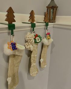 three christmas stockings hanging from hooks on the wall