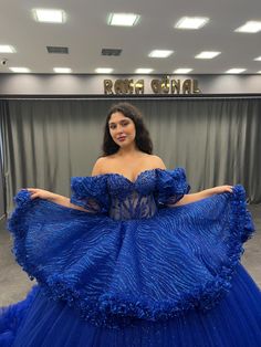 a woman in a blue dress posing for the camera