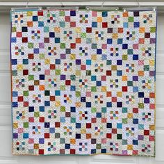 a multicolored quilt hanging on the side of a garage door