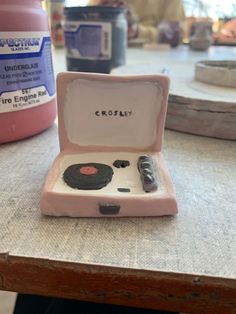 a small pink box with an electronic device in it's lid sitting on a table