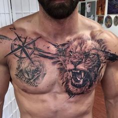 a shirtless man with tattoos on his chest has a lion and cross tattoo on his chest