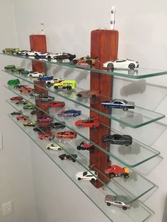 there are many toy cars on the glass shelves