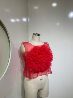 A stunning piece that combines sophistication with a touch of whimsy. This sheer top features delicate tulle fabric,the standout detail is the ruffled flower in the middle, adding a playful and feminine touch. The vibrant red hue exudes confidence and energy, making it perfect for both daytime and evening occasions. Pair it with high-waisted pants or a skirt for a chic and stylish look that will turn heads wherever you go. DETAILS Loose Round neck ruffle flower SIZE & FIT length 14” Bust 40” Size L Ruffle Flower, Red Blossoms, Tulle Fabric, Neck Ruffle, Sheer Top, Vibrant Red, High Waisted Pants, In The Middle, Round Neck