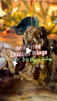 someone is holding up some kind of fried chicken wings that are being drizzled with ketchup