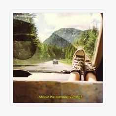 a person's feet on the dashboard of a car with mountains in the background