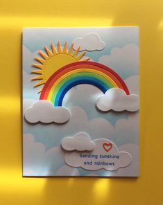 a card with a rainbow and clouds on it