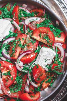 a pan filled with tomatoes, onions and feta cheese