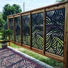 a wooden fence with metal designs on it and a potted plant in the foreground