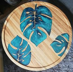 a wooden table topped with blue leaves on top of a carpeted floor next to a metal canister